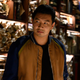 Shang-Chi (Simu Liu) stands in front of a shelf full of paper scrolls in a scene from Shang-Chi and the Legend of the Ten Rings.
